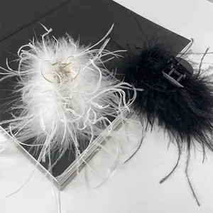 Detailed view of fluffy black and white ostrich feather hair claws on a dark vintage book