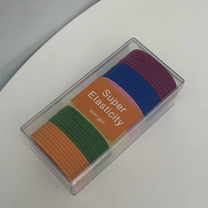 Detail view of colorful high-elastic hair ties set in a clear box with Super Elasticity label