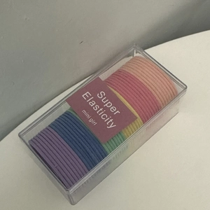 Detail view of colorful high-elastic hair ties in a transparent storage box