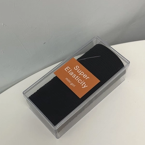 Macro shot of black high elasticity hair ties set in a clear rectangular storage box