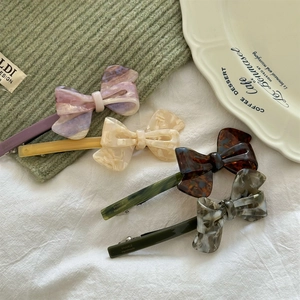 Set of four handmade acetate bow hair clips in marble texture and pastel colors
