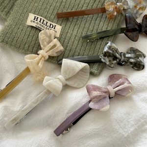 Detail view of acetate bow hair clips in various colors with France Handmade engraving