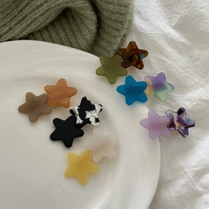 Close-up of star-shaped acetate hair clips in various colors and marble textures