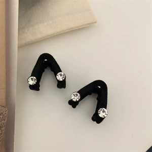 Gros plan d'une paire de barrettes à cheveux noires floquées avec détails en strass
