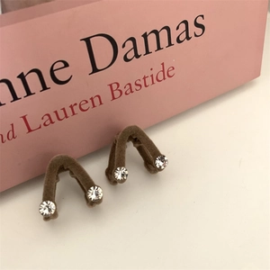 Gros plan de barrettes à cheveux en V floquées marron avec strass sur un livre