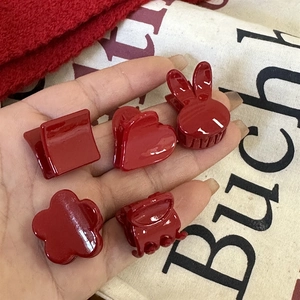 Gros plan de cinq mini barrettes à cheveux rouges en forme de cœur, lapin et fleur