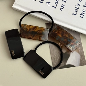 Rectangular acetate hair clip and hair tie set with tortoiseshell pattern and gold text