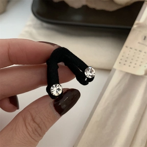 Détail de la pince à cheveux en velours noir en V avec strass brillants pour femme