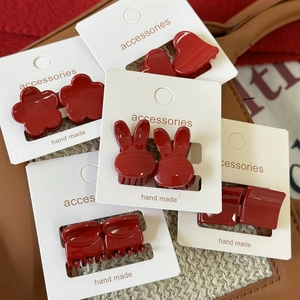 Détails de mini-pinces à cheveux rouges de formes variées sur carte de présentation