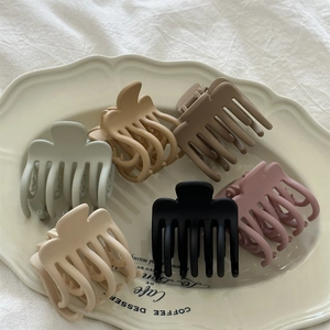 Set of six matte Morandi colored hair claws in a decorative white porcelain dish
