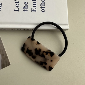 Detailed macro view of handmade tortoiseshell acetate rectangle hair clip on book