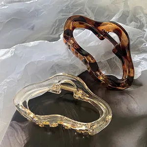 Set of two large acrylic claw clips in amber tortoiseshell and clear minimalist wave styles
