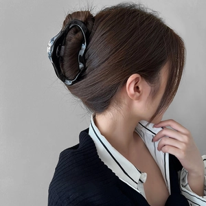 Elegant large black liquid-line hair claw clip for women styled in a chic updo