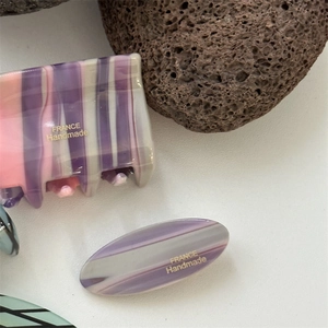 Detailed macro view of acetate marble shark hair clips with France Handmade gold lettering