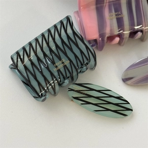 Macro shot of marble textured acetate hair clips showing fine craftsmanship details