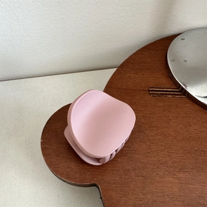 Pink matte hair claw clip for ponytail styling displayed on a bear shaped wooden tray