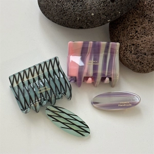 Detailed macro view of mint green checkered and purple striped acetate hair clips