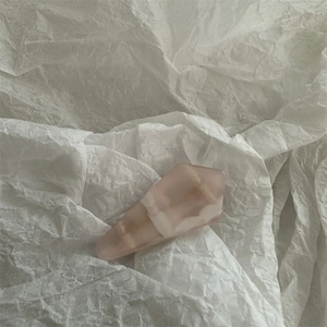 Macro view of pink marble resin hair clip with faceted geometric cut on white texture