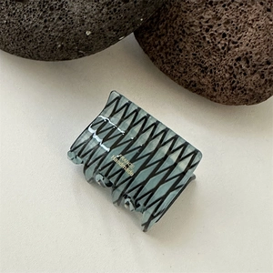 Detail view of square marble pattern hair claw clip featuring golden France Handmade text