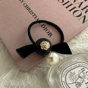 Detailed view of camellia pearl hair tie with velvet bow and golden rose bead
