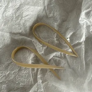 Elegant U-shaped acetate hair fork in cream beige with a minimalist twisted design