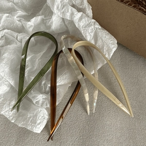 U-shaped acetate hair pins in olive green, amber, pearl white, and beige marble patterns