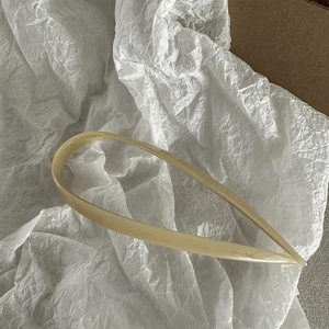 Close-up of minimalist cream acetate U-shaped hair pin with a polished finish
