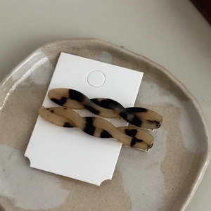 Close-up of tortoise shell pattern acetate hair clips on elegant ceramic tray display
