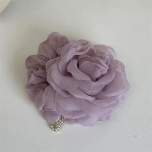 Detailed close-up of light purple mesh rose hair scrunchie with a pearl letter charm