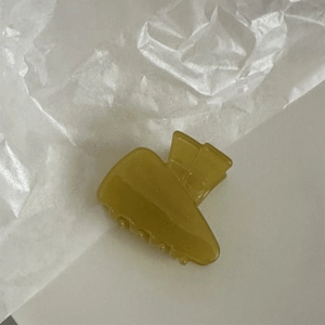 Macro shot of smooth mustard yellow acetate hair claw with high-quality resin finish