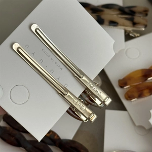 Close-up of silver metal twist hair clips on display card with Koreal engraving