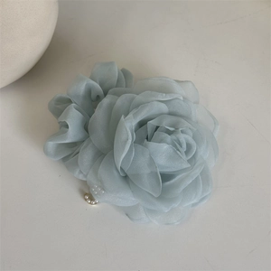 Detailed macro of dusty blue mesh rose hair tie with delicate white pearl embellishments