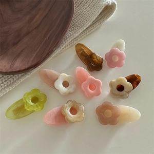 Vue de dessus de petites pinces à cheveux fleur en couleurs pastel sur tricot