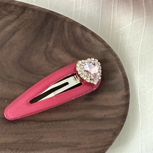 Nahaufnahme der herzförmigen Haarspange mit rosa Edelstein und glitzernden Strasssteinen
