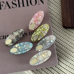 Elegant six-piece checkered acetate hair clip set with iridescent finish and gold metal plaque