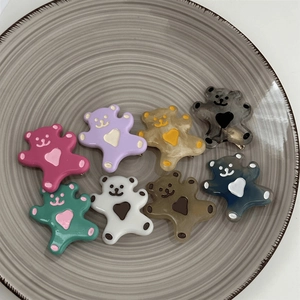 Détail de barrettes ours colorées avec motif de cœur dans un plateau rond