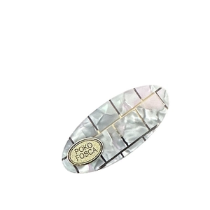 Oval pearlescent acetate hair clip with geometric pattern and gold logo plate