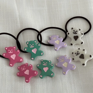 Détail de pinces à cheveux et élastiques ours colorés en rose, vert, violet et blanc