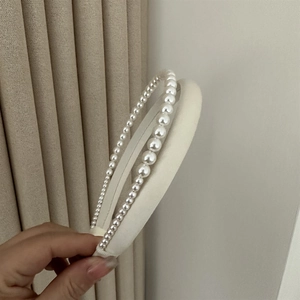 Elegant white satin padded headband with shimmering gradient faux pearls and retro style