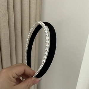 Detail showing elegant black velvet headband with lustrous gradient white pearls decoration