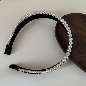 Close-up of double-layer satin headband featuring glossy white pearls and retro velvet texture