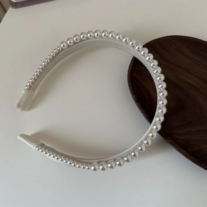 Detailed view of elegant gradient white pearls on a sleek double-layered headband