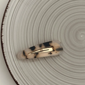 Detail of tortoise shell hair clip with gold metal spring and France Handmade logo