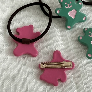 Détail de barrettes ours rose et vert avec des élastiques à cheveux assortis