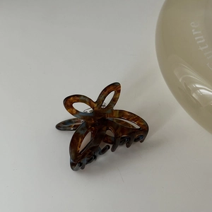 Dettaglio di una piccola pinza per capelli a farfalla in acetato con design a tartaruga