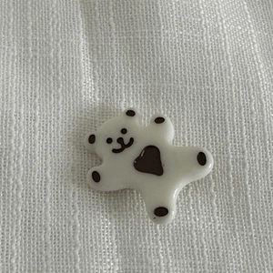 Vue macro d'une breloque ours en résine blanc crème avec cœur noir pour accessoires cheveux