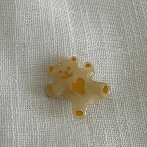 Détail de l'accessoire ours en résine ambrée avec cœur jaune pour barrettes à cheveux DIY