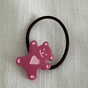 Détail d'un accessoire d'ours en résine rose sur un élastique à cheveux noir pour femmes