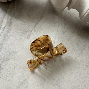 Detail of elegant amber tortoiseshell acetate hair claw clip with glossy texture