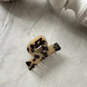 Detail view of acetate claw clip featuring a vintage tortoiseshell pattern and glossy finish